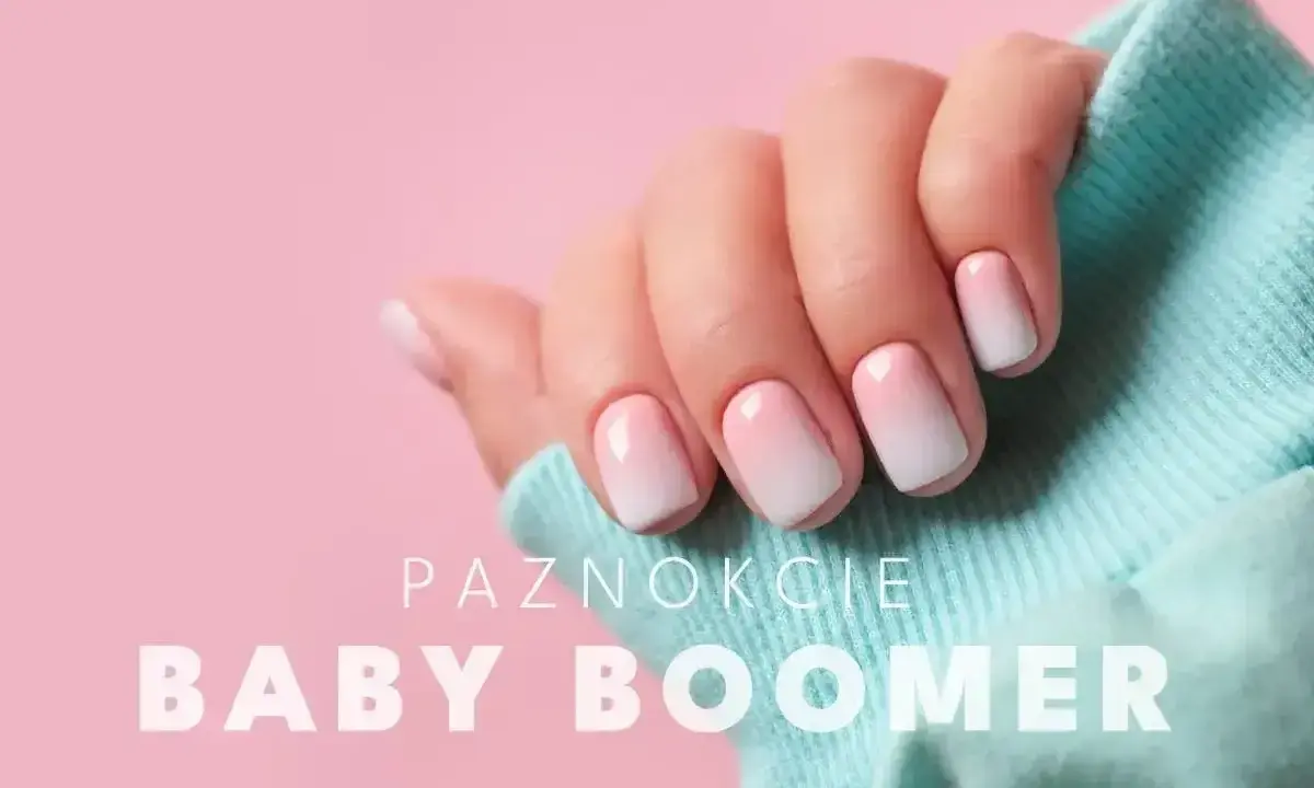Dłoń z paznokciami baby boomer, idealny french żelowy. Delikatny gradient różu i bieli na krótkich, zadbanych paznokciach.