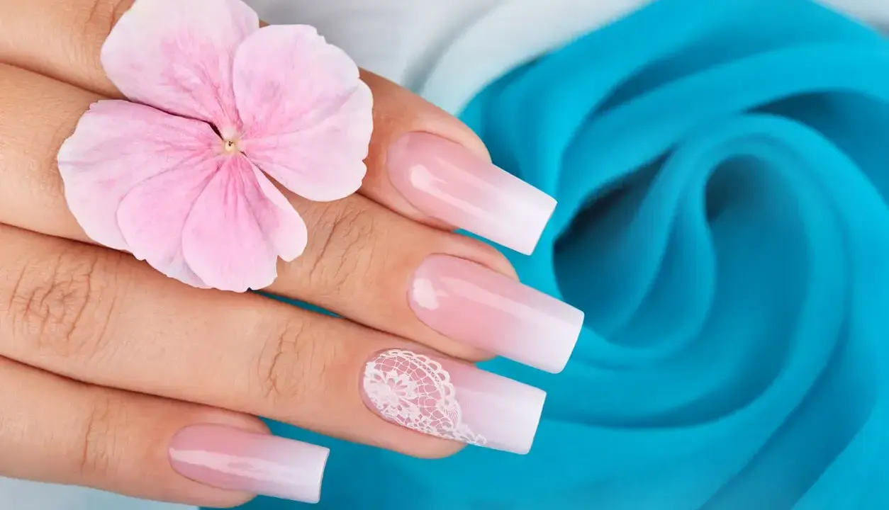 Delikatny french manicure z koronkowym zdobieniem, jak zrobić go zwykłym lakierem. Różowa hortensja na dłoni.