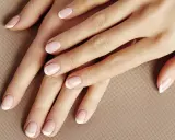 Dłonie z klasycznym french manicure. Delikatny róż i biel tworzą subtelny french pomarańczowy, podkreślając elegancję.