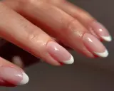 Delikatny french na okrągłych paznokciach, podkreślający naturalne piękno dłoni.