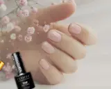 Delikatne, różowe paznokcie i buteleczki z produktami do stylizacji, w tym baza pod żel.