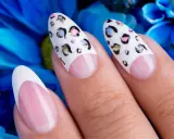 Dłonie z perfekcyjnym manicurem. Paznokcie na których nie widac odrostu, ozdobione wzorem panterki i klasycznym french manicure.