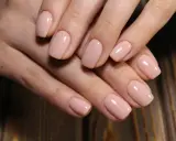 Delikatne, kwadratowe kształty paznokci żelowych w pastelowym odcieniu nude.