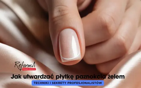 Dłoń z idealnie wykonanymi, płaskimi paznokciami w delikatnym odcieniu beżu z subtelnym brokatem.