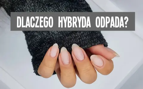 Dłoń z paznokciami, na których widać zapowietrzenie hybrydy. Szary napis: "DLACZEGO HYBRYDA ODPADA?".