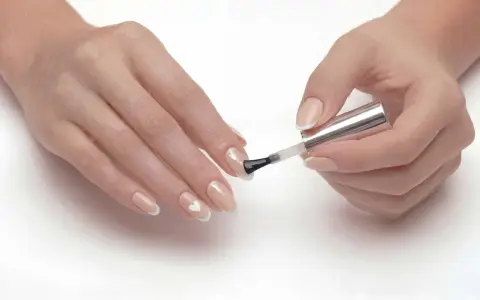 Dłonie z delikatnym manicure, gdzie paznokcie ślubne ze srebrem tworzą subtelny wzór serca.