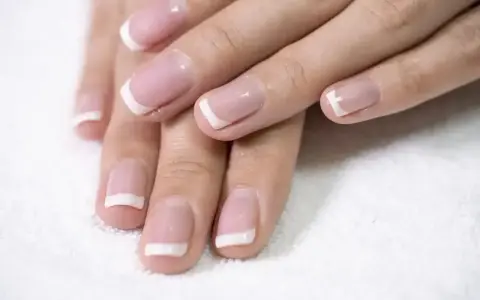 Dłonie z perfekcyjnym french kombinowanym manicure. Delikatny róż i biel podkreślają elegancję.