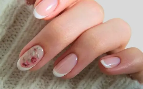 Delikatne paznokcie ślubne boho z subtelnym zdobieniem w postaci różowych kwiatów na jednym z paznokci. Klasyczny french manicure w nowoczesnym wydaniu.