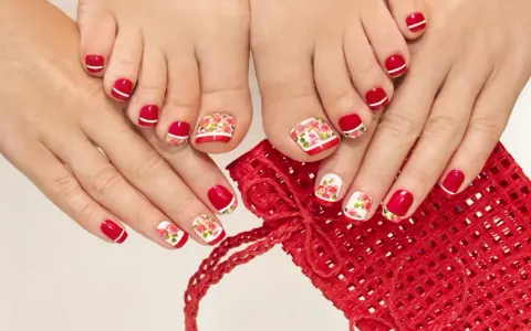 Dłonie i stopy ozdobione klasycznym lakierem w kolorze czerwonym z białymi paskami i motywem róż.