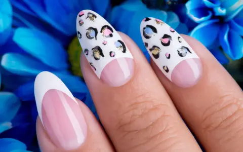 Dłonie z perfekcyjnym manicurem. Paznokcie na których nie widac odrostu, ozdobione wzorem panterki i klasycznym french manicure.