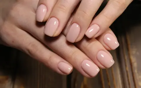 Delikatne, kwadratowe kształty paznokci żelowych w pastelowym odcieniu nude.
