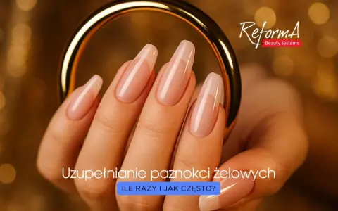 Dłoń z idealnie wykonanymi paznokciami żelowymi, prezentującymi prawidłową budowę. Złota obręcz podkreśla elegancję.