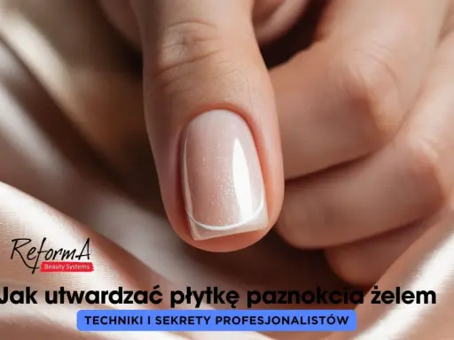 Dłoń z idealnie wykonanymi, płaskimi paznokciami w delikatnym odcieniu beżu z subtelnym brokatem.