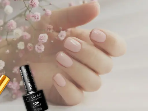 Delikatne, różowe paznokcie i buteleczki z produktami do stylizacji, w tym baza pod żel.