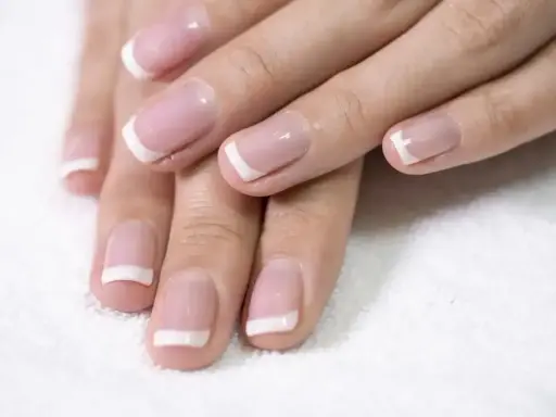 Dłonie z perfekcyjnym french kombinowanym manicure. Delikatny róż i biel podkreślają elegancję.