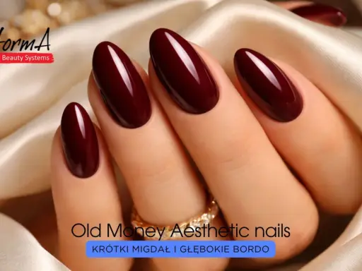 Eleganckie paznokcie w odcieniu głębokiego bordo, o migdałowym kształcie, ozdobione złotym pierścionkiem.