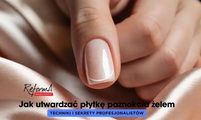 Dłoń z idealnie wykonanymi, płaskimi paznokciami w delikatnym odcieniu beżu z subtelnym brokatem.