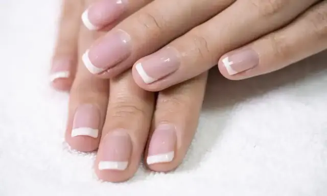 Dłonie z perfekcyjnym french kombinowanym manicure. Delikatny róż i biel podkreślają elegancję.