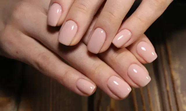 Delikatne, kwadratowe kształty paznokci żelowych w pastelowym odcieniu nude.