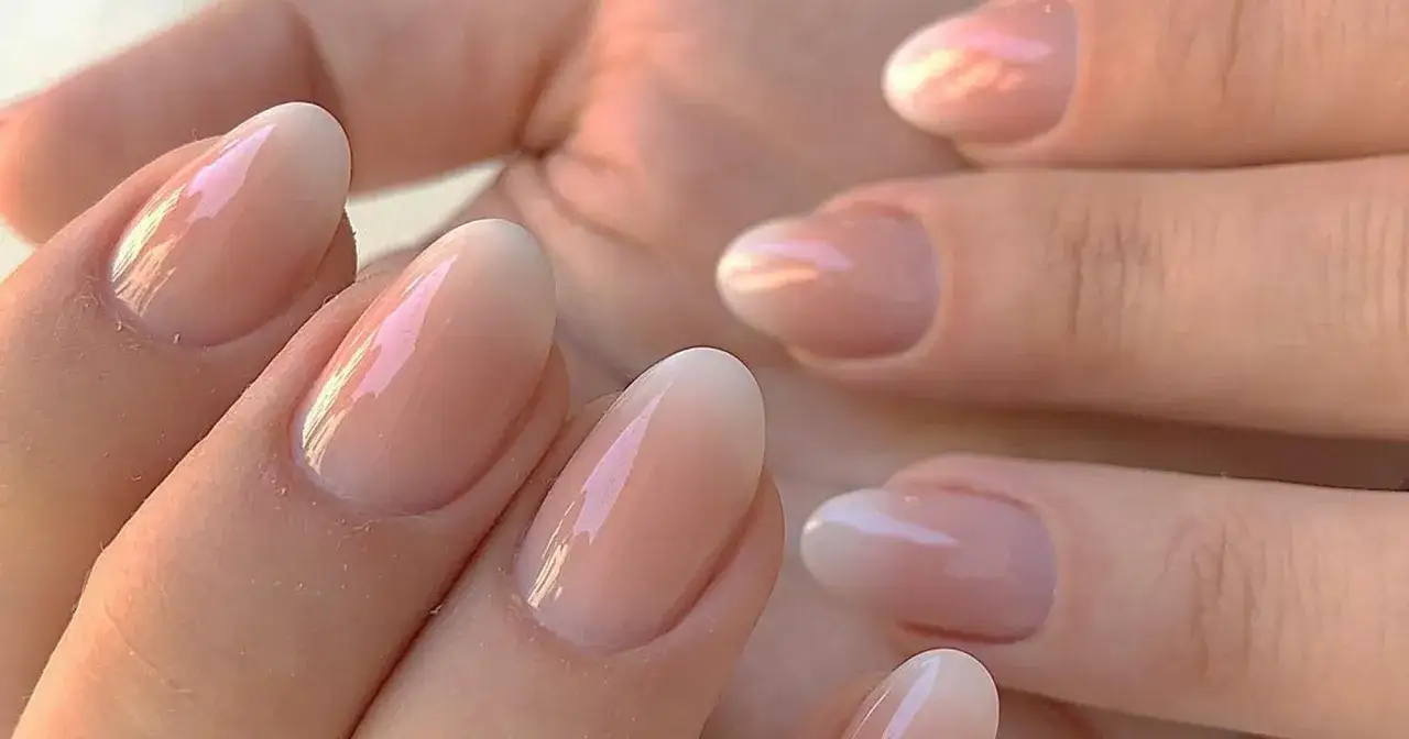 Delikatny french trojkatny manicure na migdałowych paznokciach, z subtelnym połyskiem.